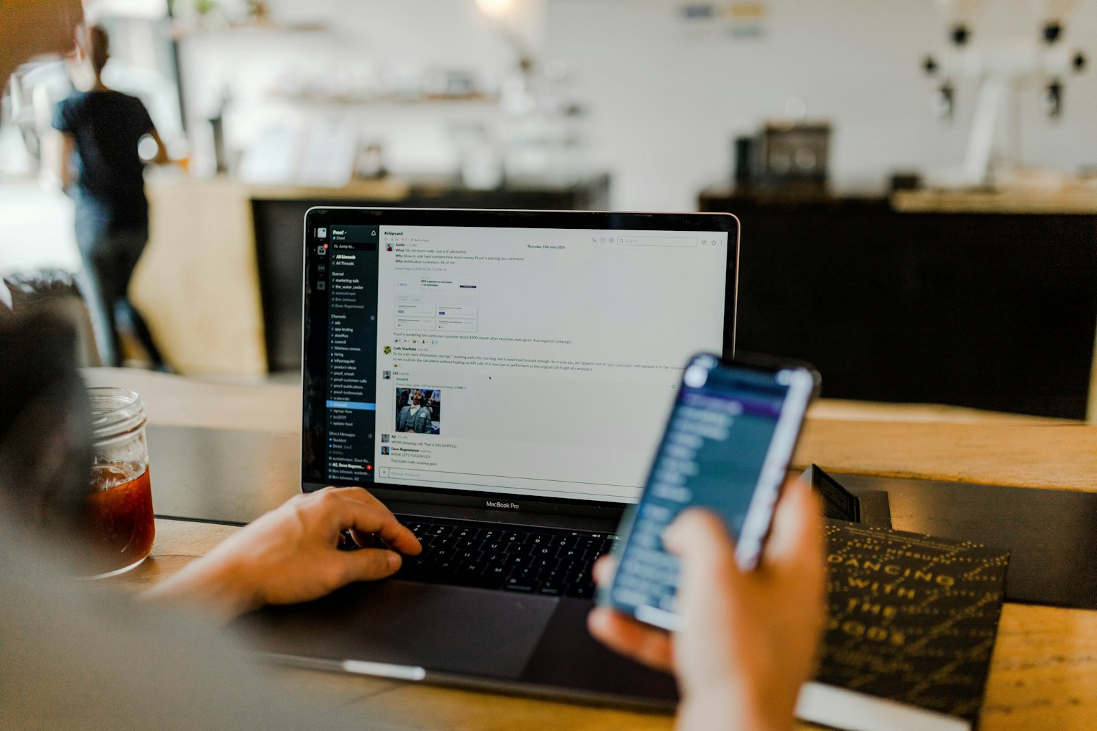 Person using a phone and laptop